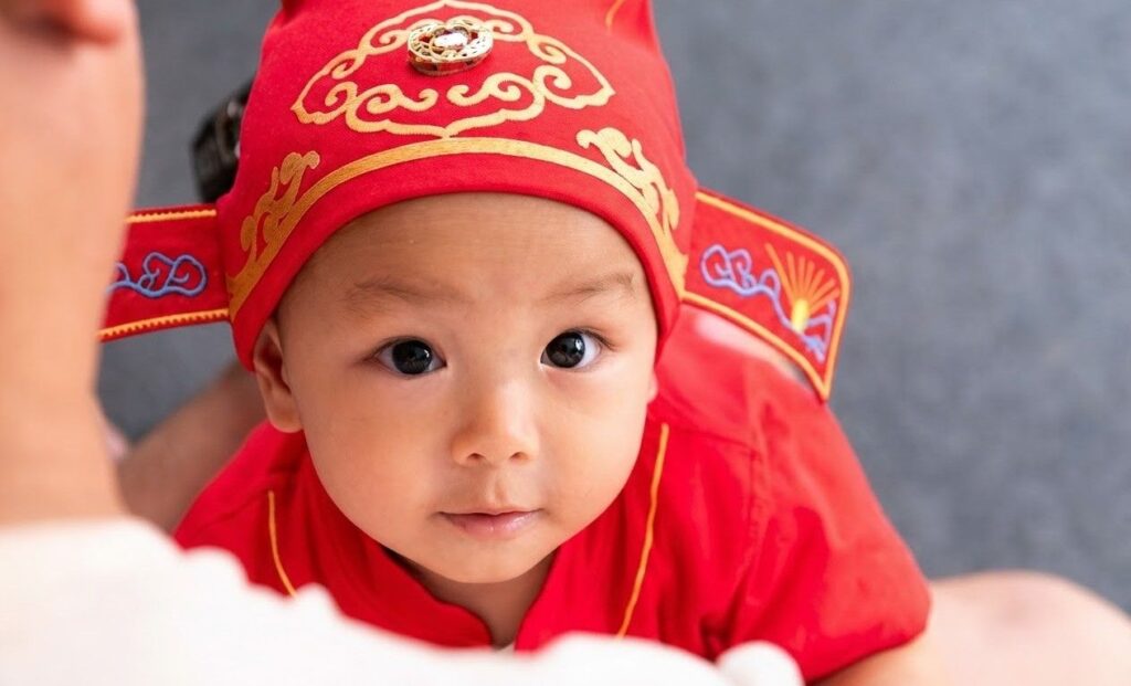 baby China wearing a red ornamental hat s 1024x621